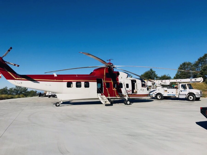 Helicopter and support vehicles staged for infrastructure field operations